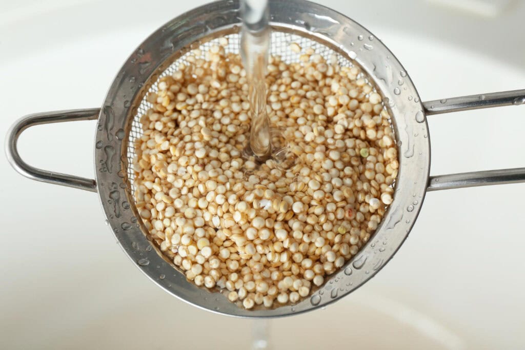 Mencuci quinoa dengan air mengalir untuk menghilangkan saponin